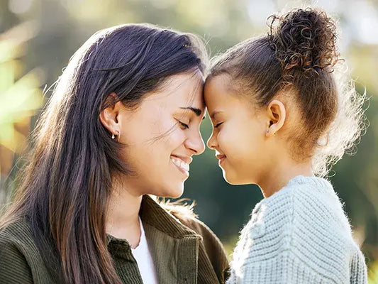 Mother holding child, both smiling 