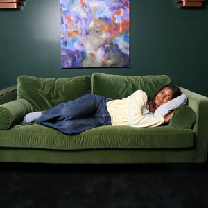 Girl laying on the sofa using the Hand-Hugger Weighted Pillow