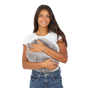 Girl smiling while holding the Hand-Hugger Weighted Pillow
 