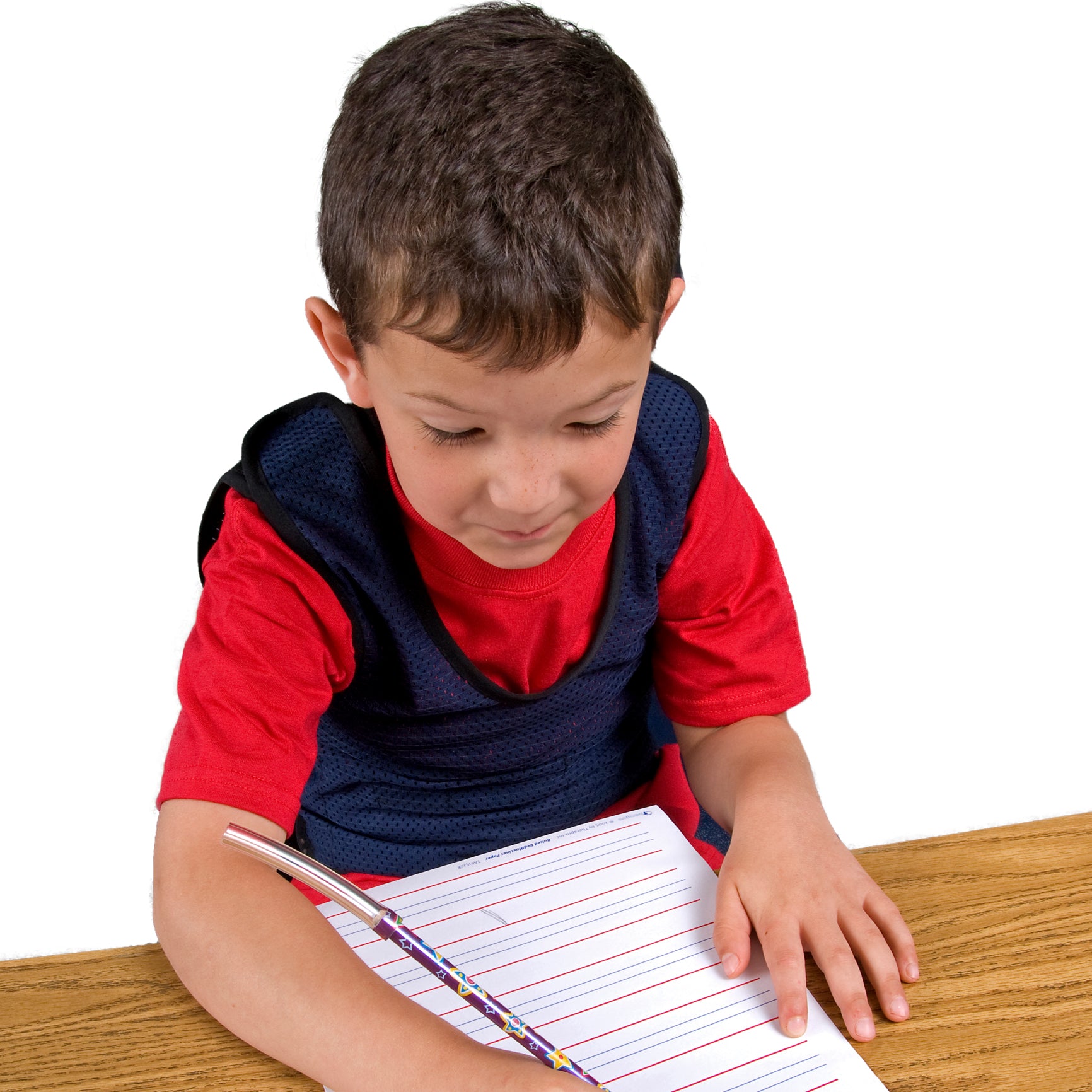 Boy writing while using the Chew Pencil Jaw