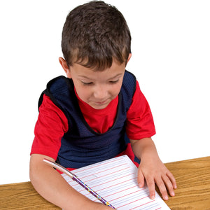 Boy writing while using the Chew Pencil Jaw