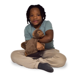 Boy sitting and holding the Weighted Animal Lap Pad