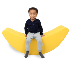 Child sitting on the SensaSoft™ Banana Rocker