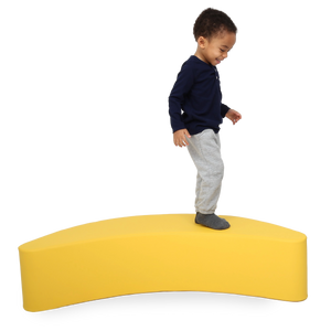 Child standing on the SensaSoft™ Banana Rocker
