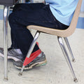 boy using a stretchy red resistance band around the front legs of his chair