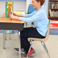 Boy reading a book while using the Quiet Fidget for Feet