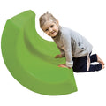 Child smiling while using the green SensaSoft™ Rocking Half Barrel