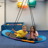 girl and boy sitting together indoors on the Magic Carpet Swing 