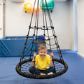 boy smiling while sitting on the black Web Tower Swing