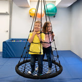 girl and boy smiling while standing on the black Web Tower Swing