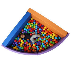 Top view of child laying in the SensaSoft™ Foldable Ball Pit - Corner