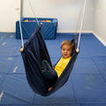 boy sitting indoors in the blue Soft Taco Swing