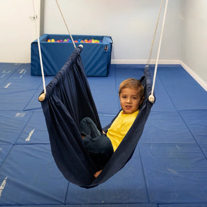 boy sitting indoors in the blue Soft Taco Swing
