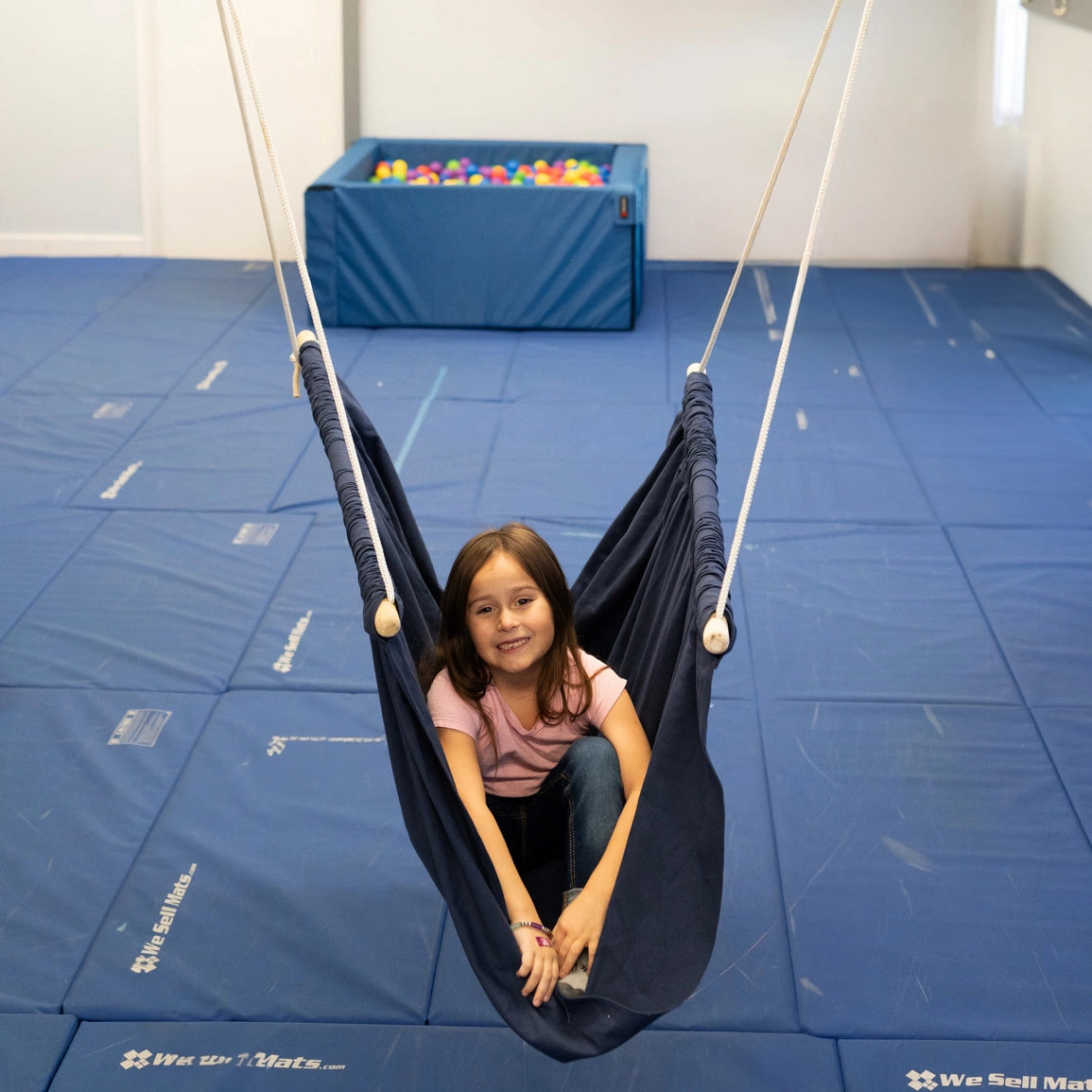 girl sitting indoors in the blue Soft Taco Swing