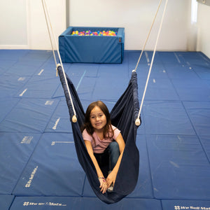 girl sitting indoors in the blue Soft Taco Swing