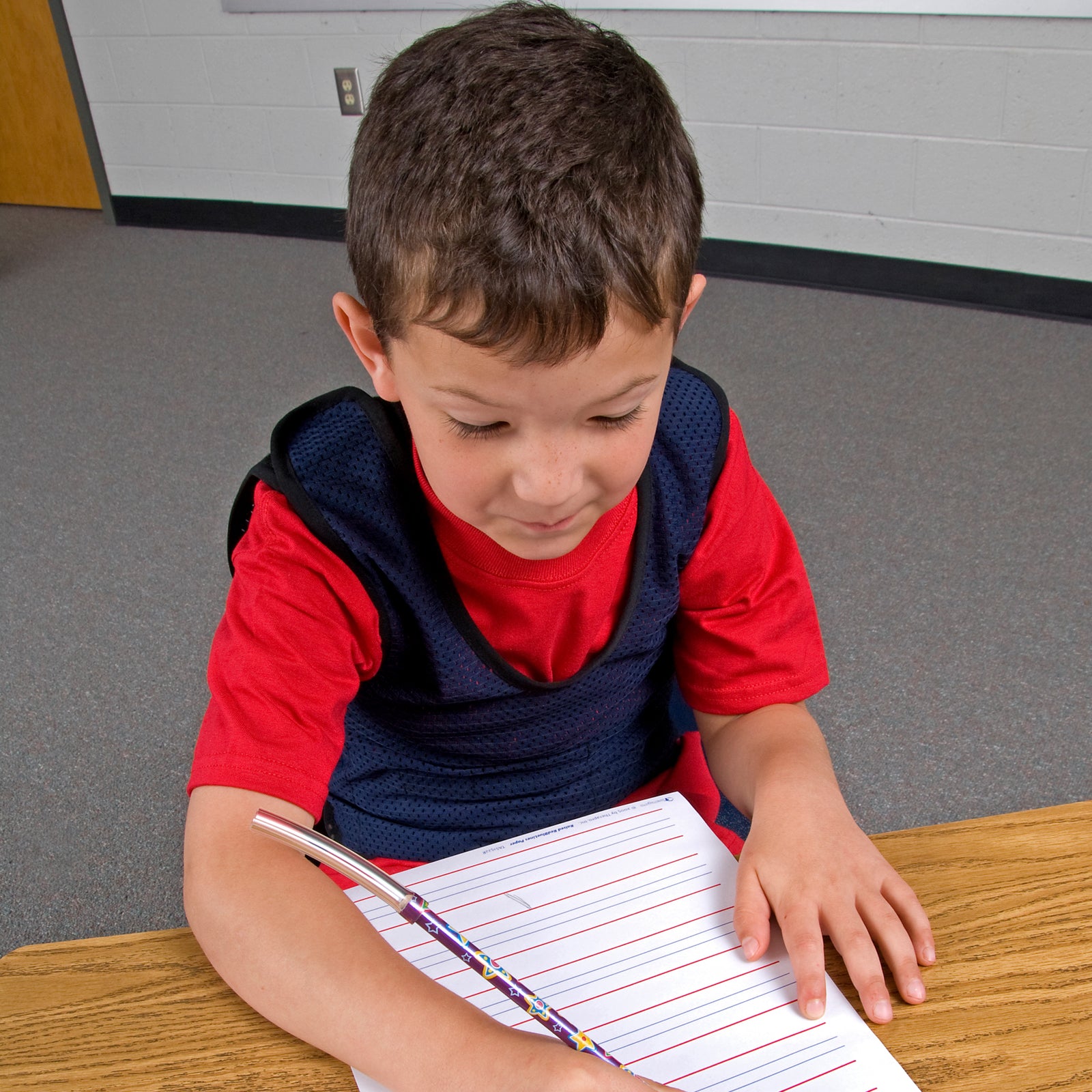 Boy working at a desk while wearing the Pressure Mesh Vest