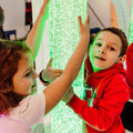 kids holding onto the brightly-colored Calming LED Bubble Tube