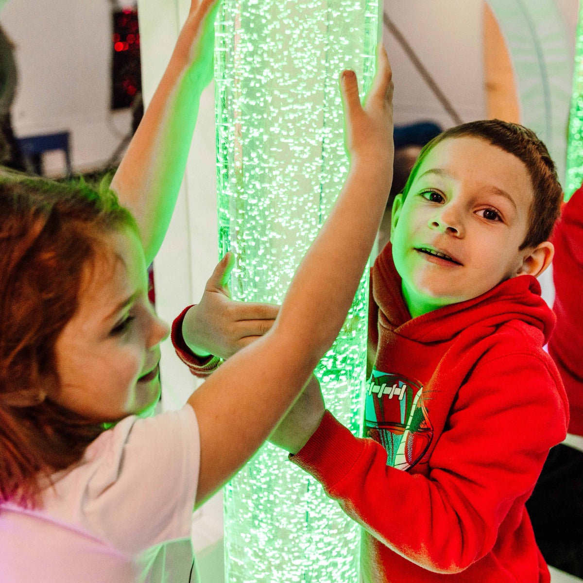 kids holding onto the brightly-colored Calming LED Bubble Tube