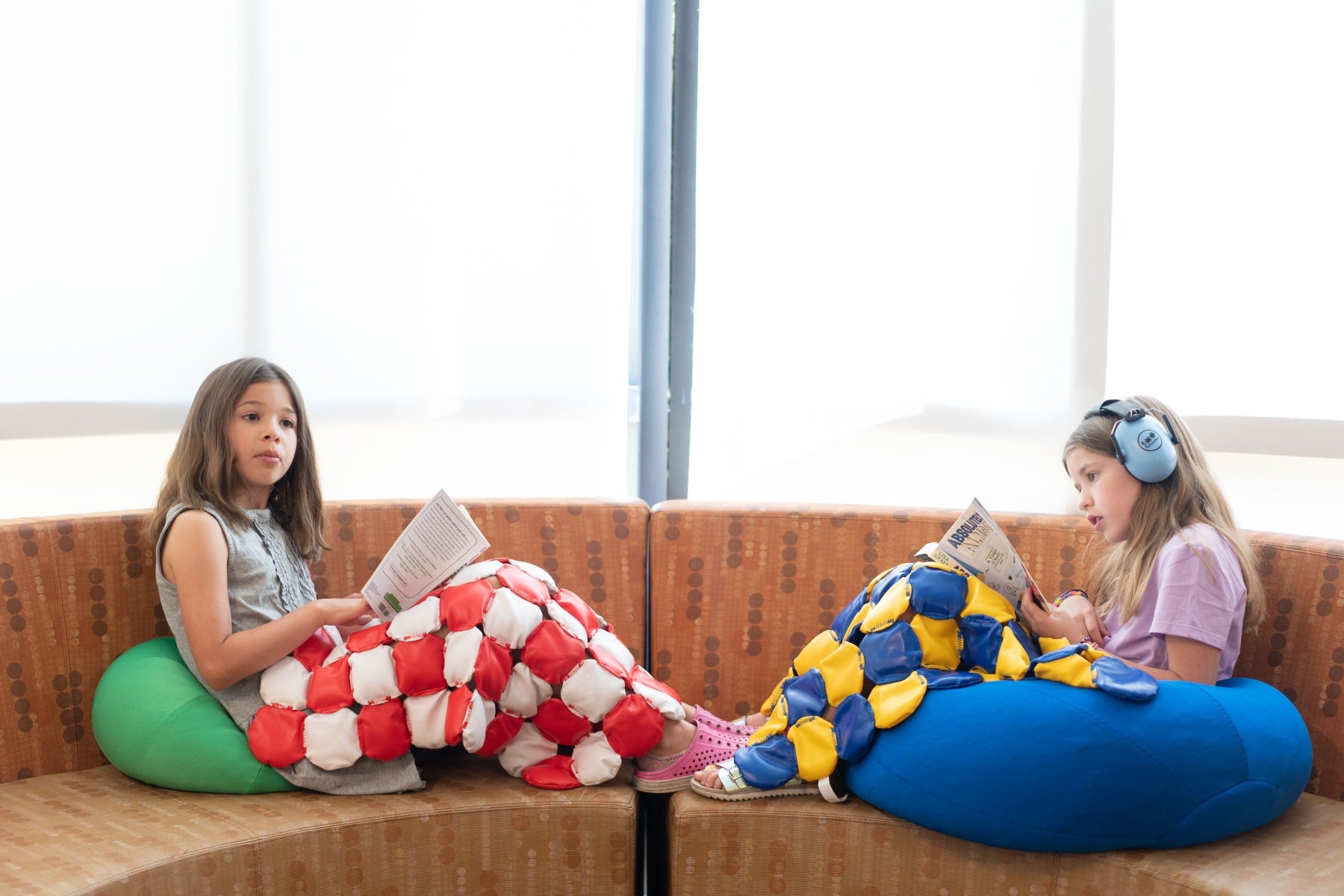 Two girls playing using the Weighted Disc Blankets