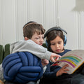 Two children reading while holding the Weighted Sensory Knot Ball