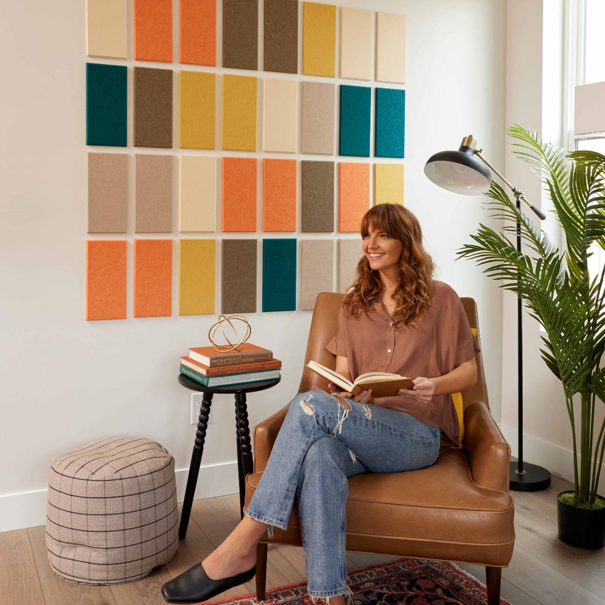 Woman reading a book in a room with Felt Right Tiles in design Mosaic Autumn