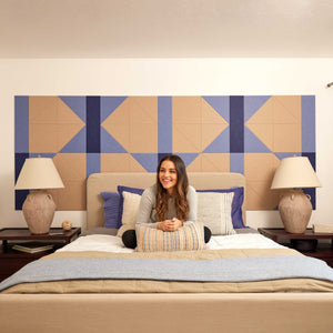 Woman smiling on a bed in a room with Felt Right Tiles Hourglass design