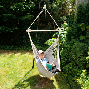 Boy reading while using the Hanging Hammock Chair in the garden