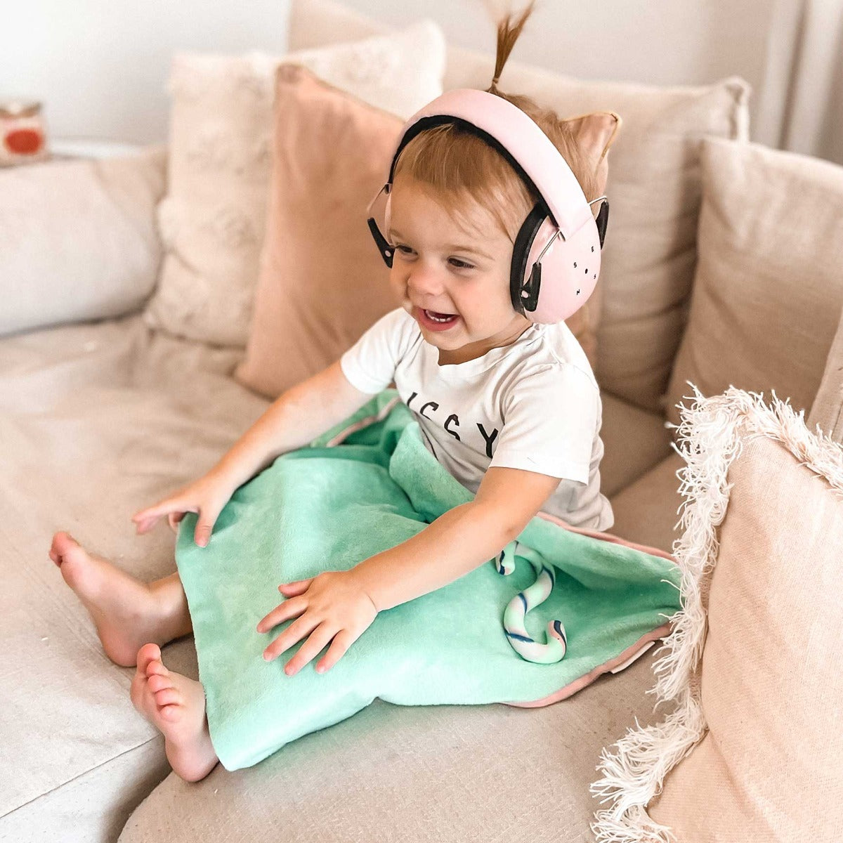 Child smiling while using the Sensory Basics Weighted Lap Pads