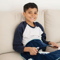 Child smiling while using the Sensory Basics Weighted Lap Pad