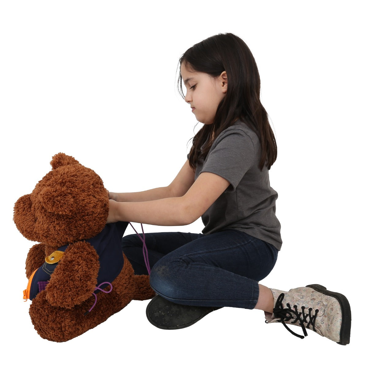 Girl putting the Mini Me Dressing Vest on the teddy bear