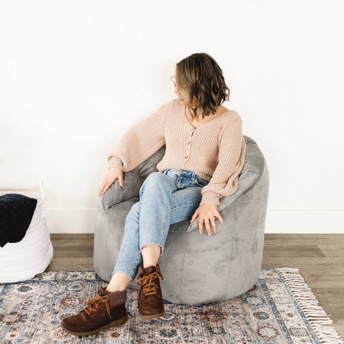 Woman smiling while sitting on the Plush Gray Big Joe Milano