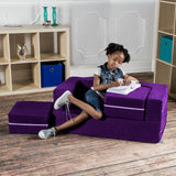 Child sitting on purple Zipline Convertible Loveseat while writing notes