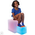 Girl smiling while sitting on the LimeLite™ LED Cube