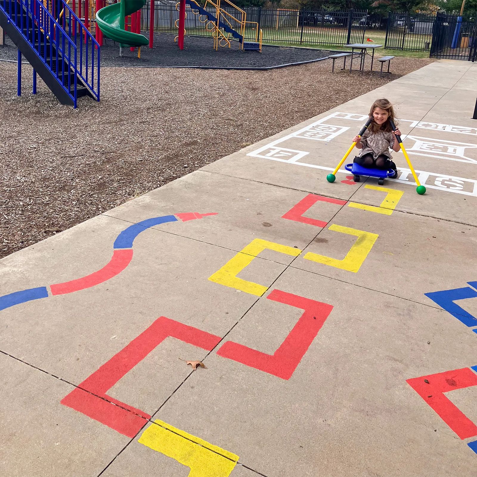 child riding on a path created from the child playing on the Outdoor Paint-A-Path