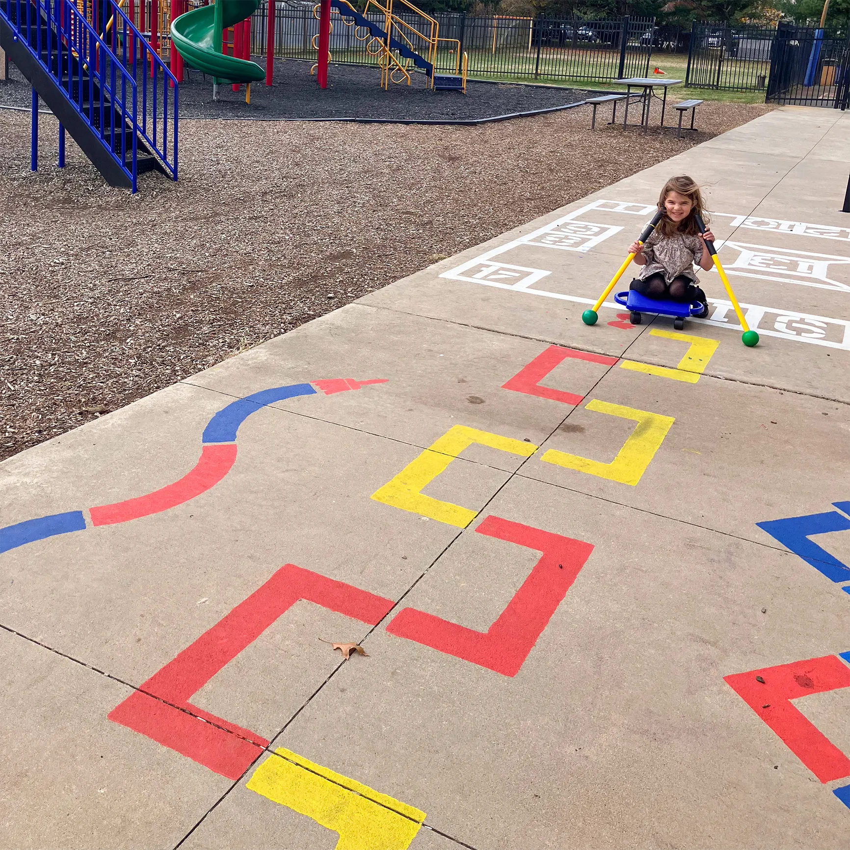 child riding on a path created from the child playing on the Outdoor Paint-A-Path