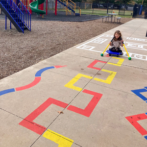 child riding on a path created from the child playing on the Outdoor Paint-A-Path