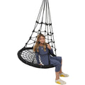 Girl smiling while sitting on the Web Tower Swing
