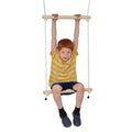 Child hanging from the top bar while seated on a double trapeze swing