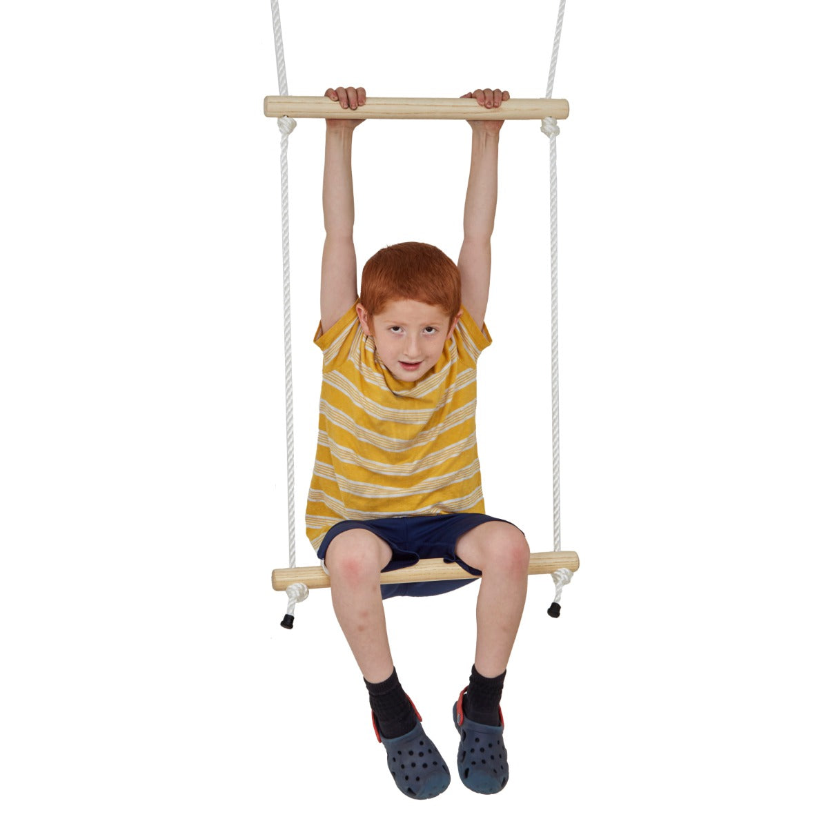 Child hanging from the top bar while seated on a double trapeze swing