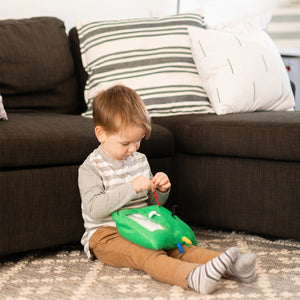 Boy playing with the Busy Fingers™ Fidget Lap Pad