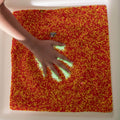 Hand inside the LimeLite™ LED Sand Table