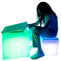Girl sitting on smaller  blue LimeLite™ LED Sand Table while plaing with the bigger green sand table