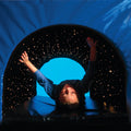 Child laying under the SensaSoft™ Fiber Optic Tunnel