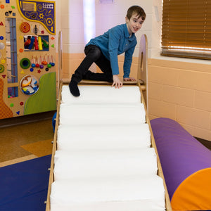 Boy smiling while using the LED Sensory Roller Slide