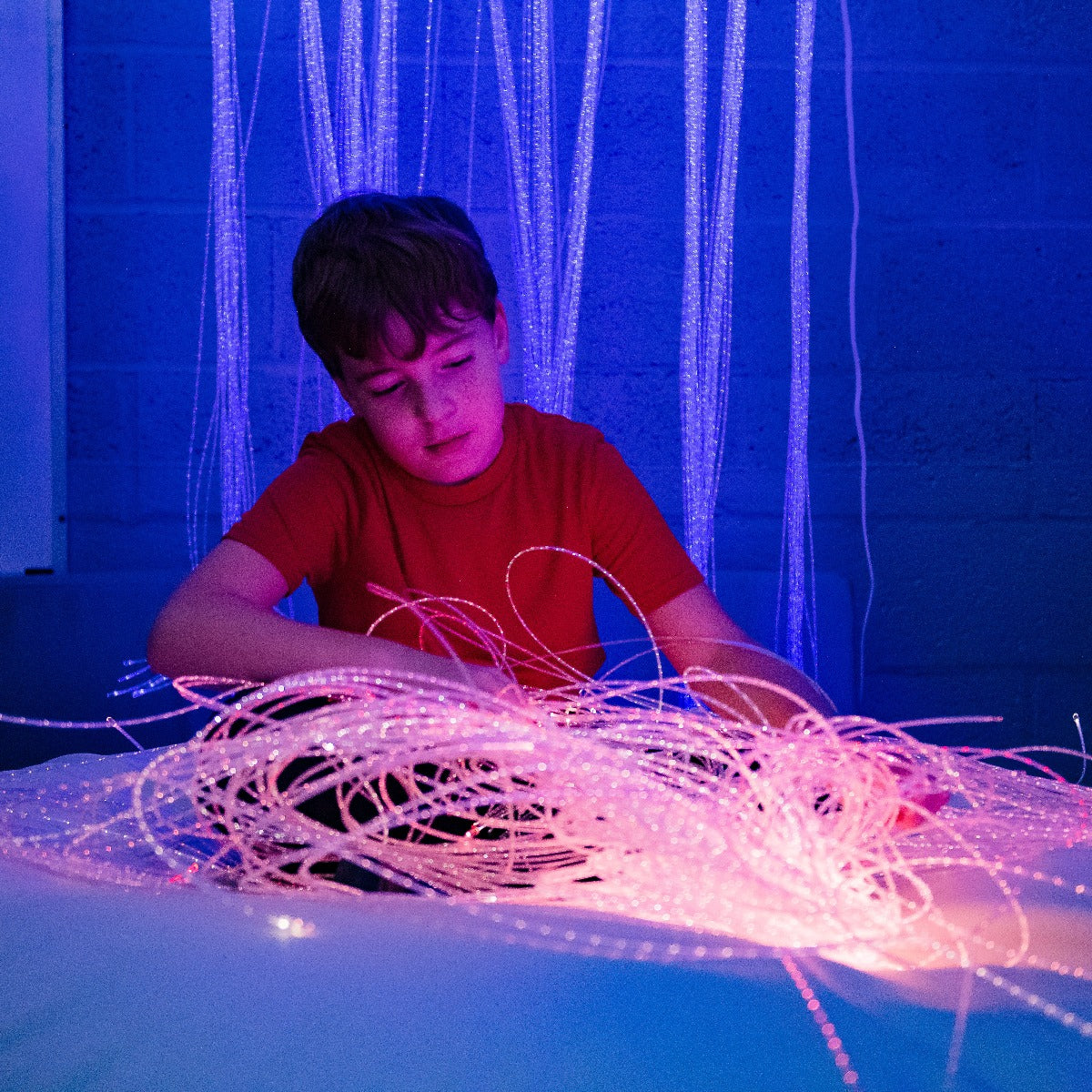 Boy playing with the Fiber Optic LED Strands With Lightsource