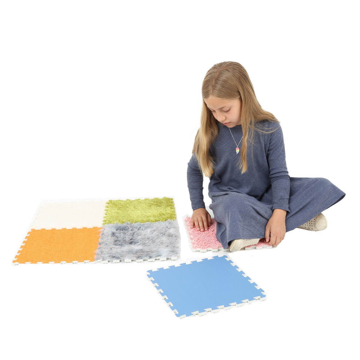 Girl sitting down and touching the Tactile Play Mat