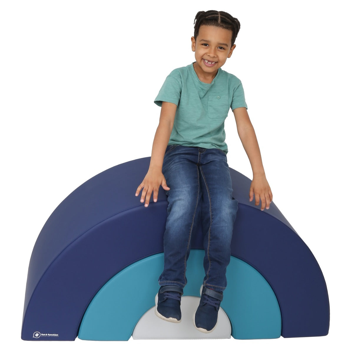 Boy smiling while sitting on the SensaSoft Rainbow Playset