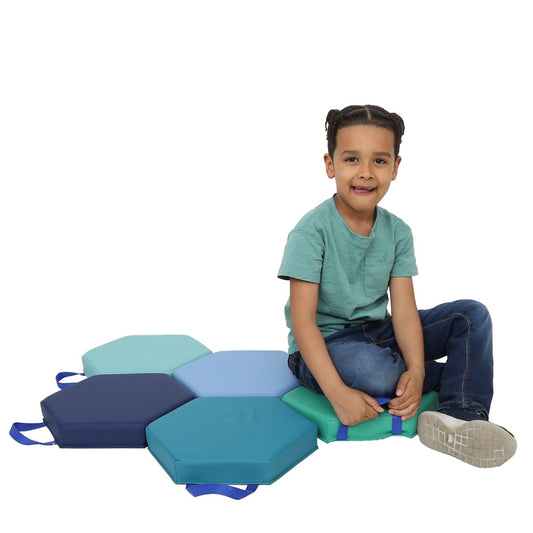 Boy smiling while sitting on the Honeycomb Cushions in Colors: Navy, turquoise, green, teal, sky blue, grey and royal blue handles