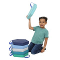 Boy smiling while holding and playing with the Honeycomb Cushions in Colors: Navy, turquoise, green, teal, sky blue, grey and royal blue handles