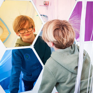 Boy smiling while looking at the Honeycomb Mirrors